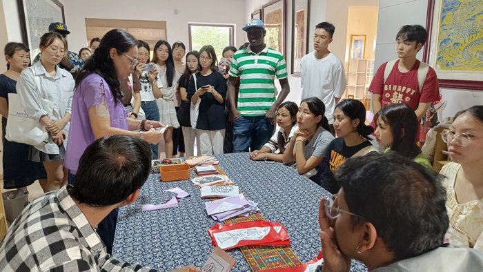 1699341138943367.jpg 2.黄会长展示剪纸技艺.jpg